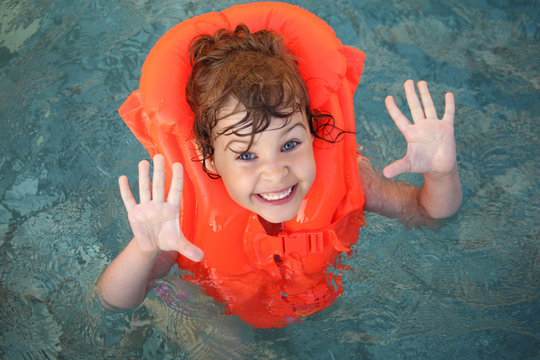 Little Girl In Inflatable Waistcoat In Pool