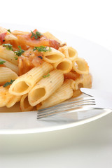 Pasta with organic tomato on a white plate