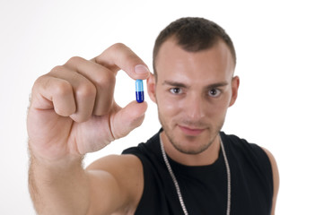 Fototapeta premium Studio shoot of young caucasian man with pill focus on pill