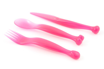 Pink colored plastic cutlery over white background