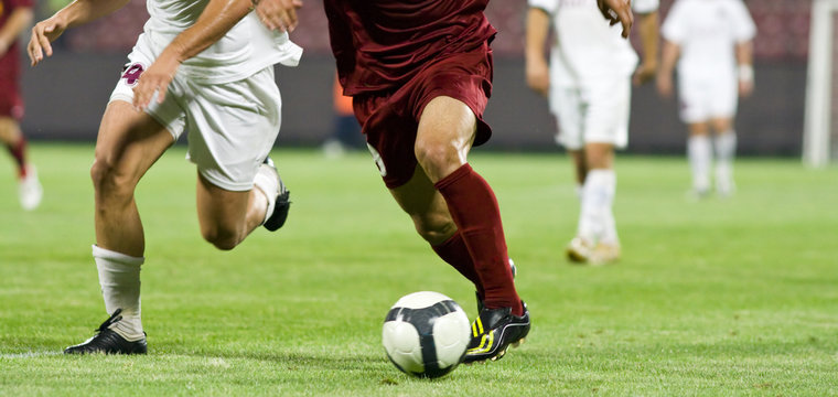 Soccer players running after the ball
