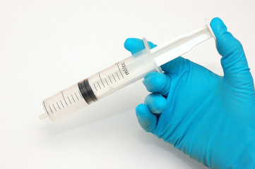 Hand in surgical glove holding syringe