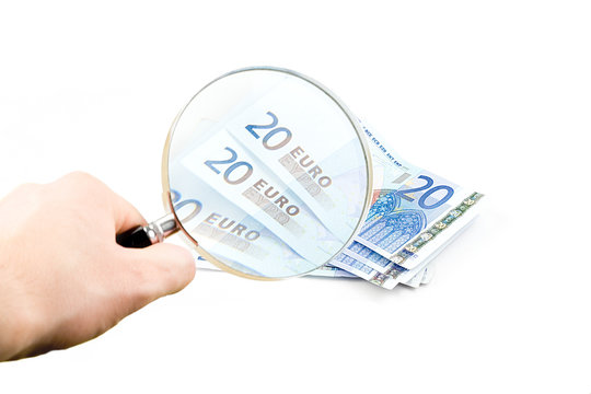 Isolated euro money under the reading glass kept in hand