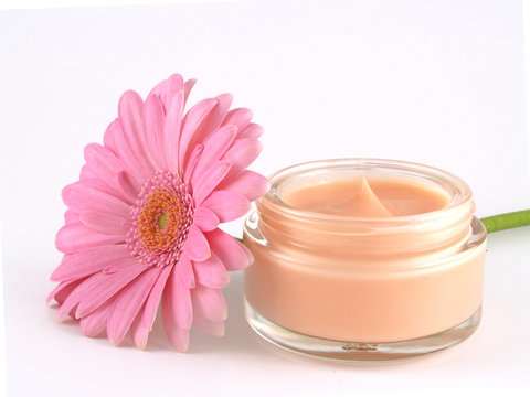 a jar of face cream with a flower