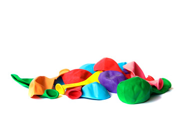 Many deflated colored balloons isolated on white