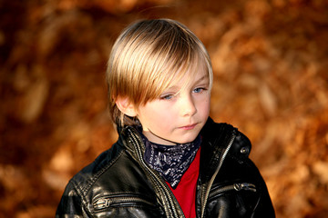Blonder Junge mit Lederjacke im Herbst