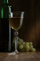 Bottles and glasses of wine on a dark background
