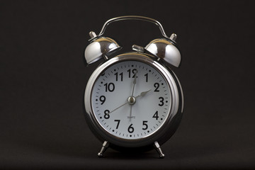 Nice old vintage chrome metal twin bell alarm clock on black background.