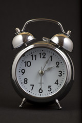 Nice old vintage chrome metal twin bell alarm clock on black background.