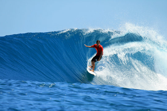 Surfer riding perfect tropical blue wave, Mentawai, Indonesia