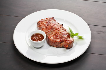Juicy beef steak with red hot sauce and oregano leaf