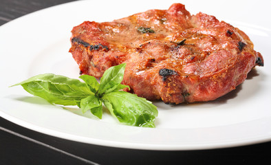 Grilled pork chop on a white plate