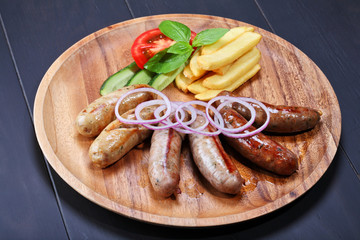Assortment of grilled sausages on the wooden plate