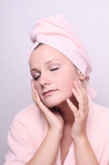 young woman applying creme on face