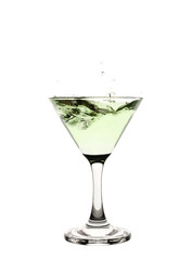 Green liquid splashing in a martini glass.