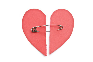 Red paper heart torn in half secured with safety pin