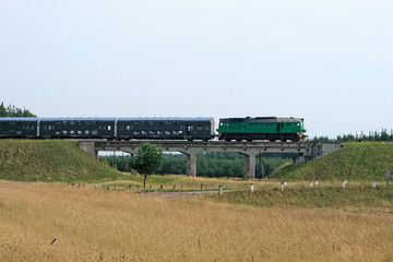 Fototapeta na wymiar Passenger train passing through polish countryside
