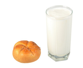 Milk in transparent glass and yellow-orange bagel.