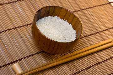 bowl with rice on mat with sticks
