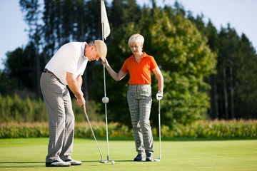 Mature couple playing Golf