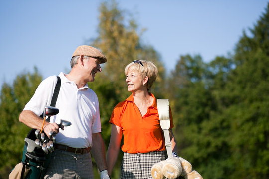 Mature couple playing Golf