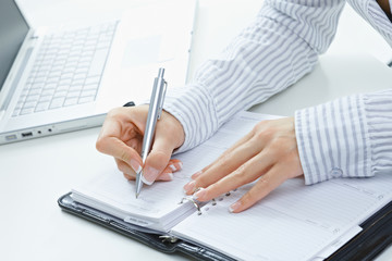 Female hand writing notes