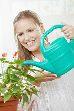 Young woman watering plant