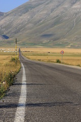 Castelluccio di Norcia. La strada  tra la campagna.