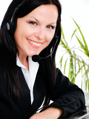 smiling brunette woman with headphone in office