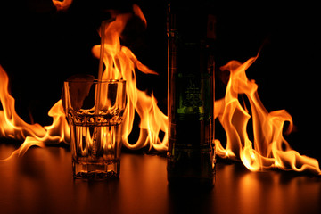 Glass and bottle on bar rack in fire