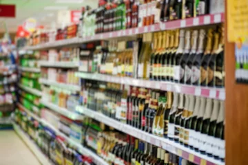Photo sur Plexiglas Bar Shelf with beer bottles in a supermarket, blur