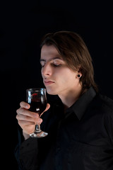 Handsome vampire with glass of wine or blood