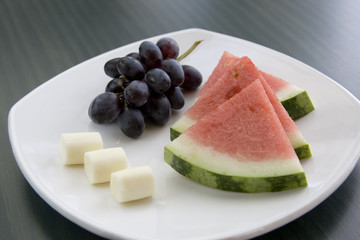 A plate of fresh fruit and cheese.