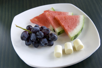 A healthy plate of fruit and cheese.
