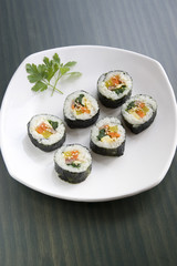 A type of sushi called kimbap and a parsley leaf.