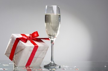 Glasses of champagne, gifts with red tapes and bows