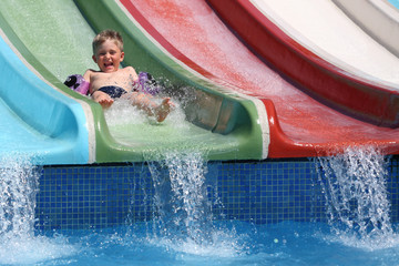 The boy slides a waterslide.