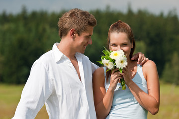 Romantic portrait of young couple  with aster flowers