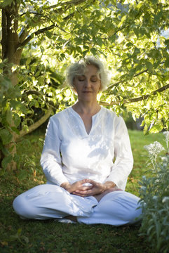 Meditierende Frau sitzt inmitten der Natur