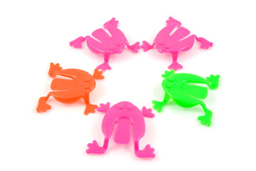 colorful plastic frog toys over white background