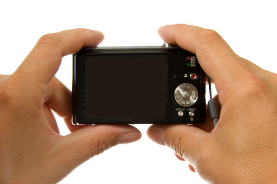 Hands with digital photo camera over white background
