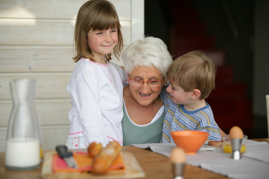 Senior souriante pr&egrave;s d'un petit gar&ccedil;on et d'une petite fille
