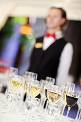 Set of wine glasses with waiter on blurred background