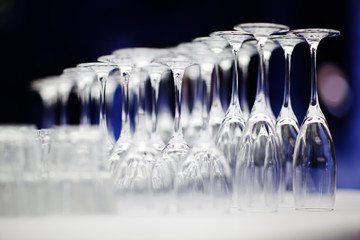 Upturned set of wine glasses on blurred blue background