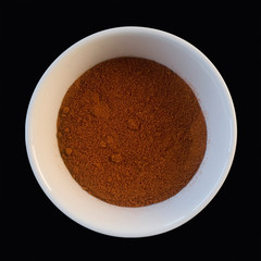 grounded red pepper in white cup