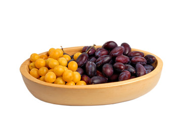 Two kinds of Plums in a wooden bowl