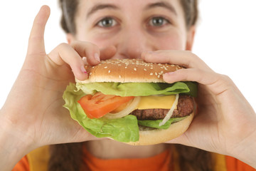 adolescente mange un hamburger