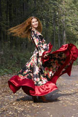 A beautiful ginger-haired girl in gipsy suit in dance whirlwind