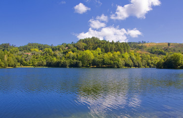 Beautiful landscape with lake in forest and clouds
