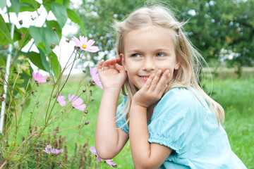 young girl listening to a flower